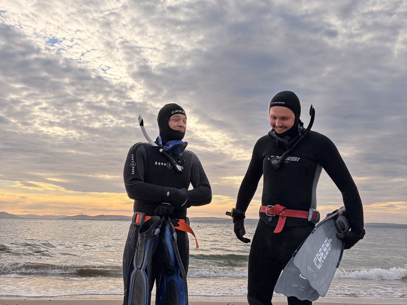 Two divers coming ashore at dawn